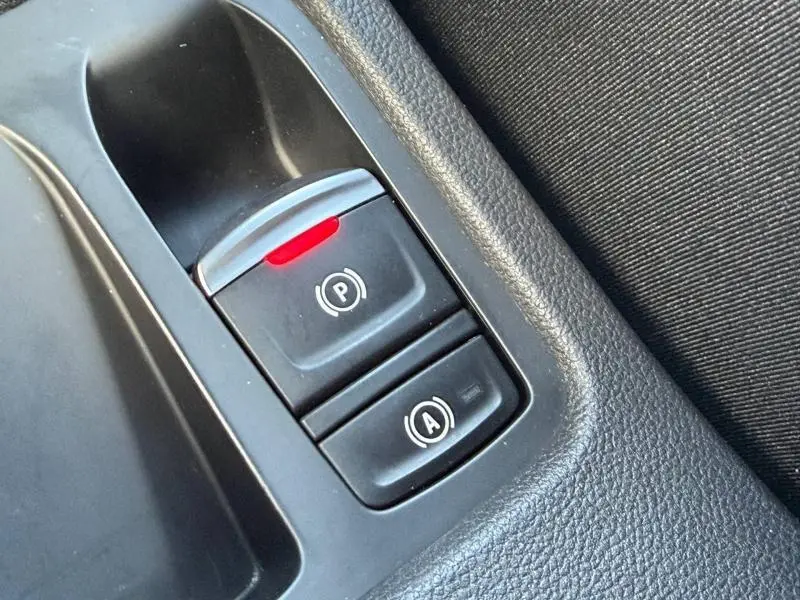 Gros plan sur les commandes de frein à main électronique et arrêt automatique dans l'habitacle d'une Renault Clio 2025.