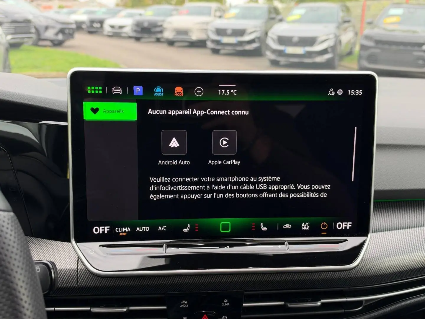 Écran tactile central de la Volkswagen Golf 1.5 eTSI blanc, vue intérieure frontale avec commandes climatisation visibles.