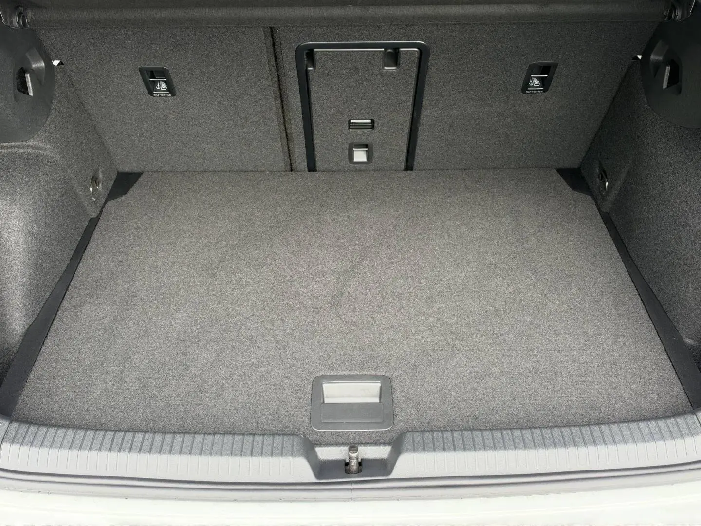Vue plongeante sur le coffre spacieux et tapissé de gris d'une Volkswagen Golf 1.5 eTSI EVO2 blanc Oryx nacré.