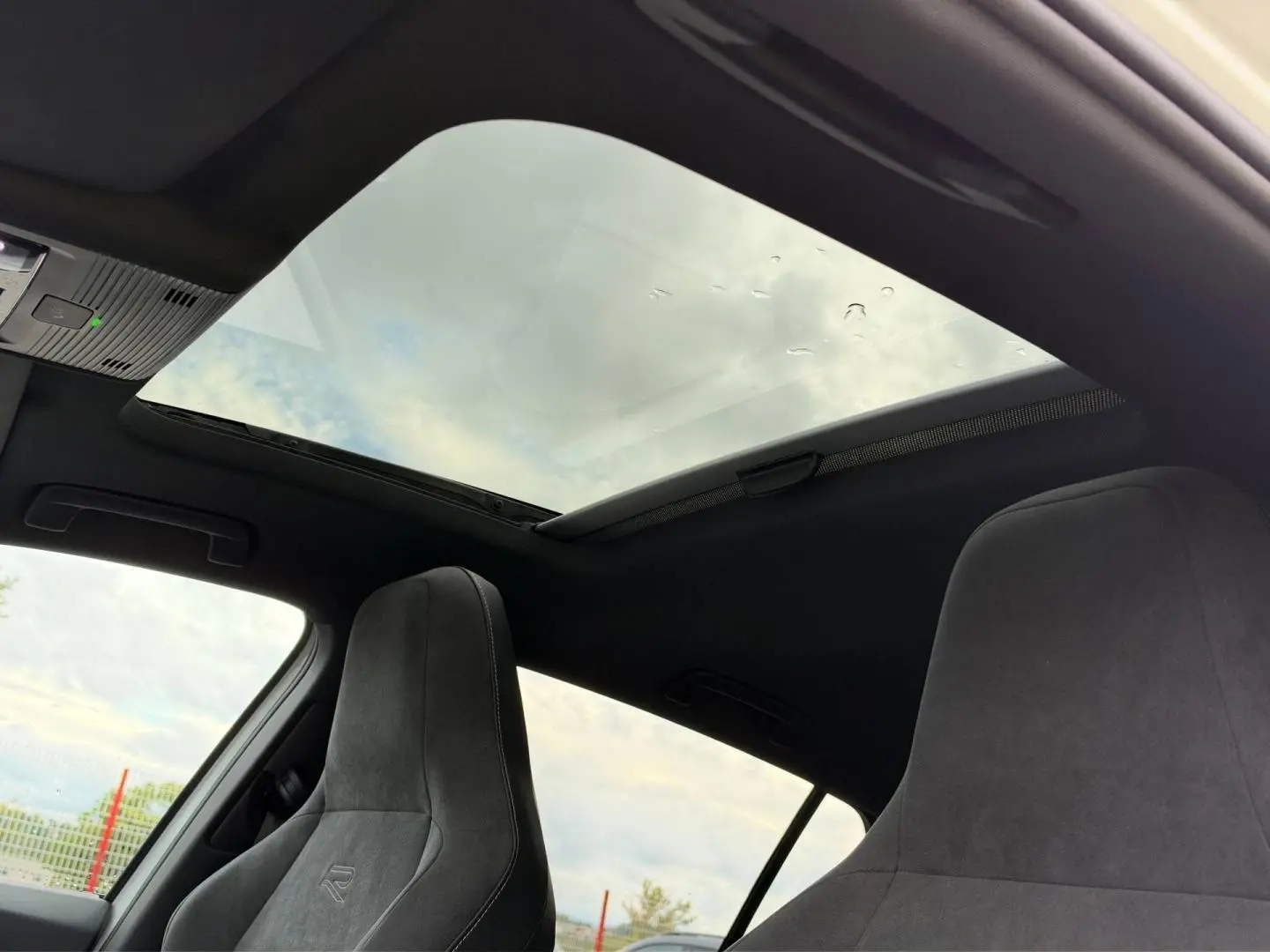 Vue intérieure du toit ouvrant panoramique et des sièges sport gris anthracite de la Volkswagen Golf 1.5 eTSI R-Line 2025.
