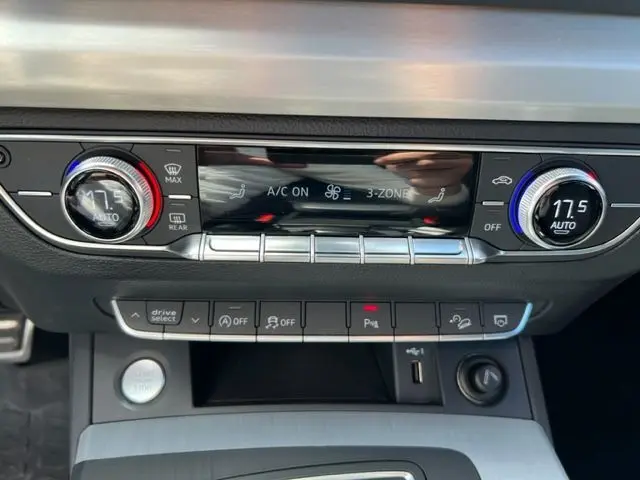 Panneau de contrôle de climatisation 3 zones de l'Audi Q5 2018 avec boutons argentés et affichage digital noir.