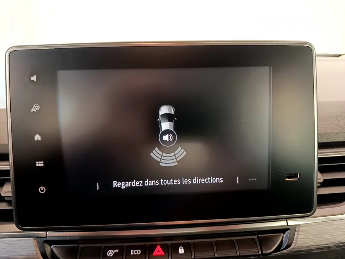 Écran tactile central du tableau de bord du Renault Kangoo bleu 2023 affichant l'aide au stationnement.