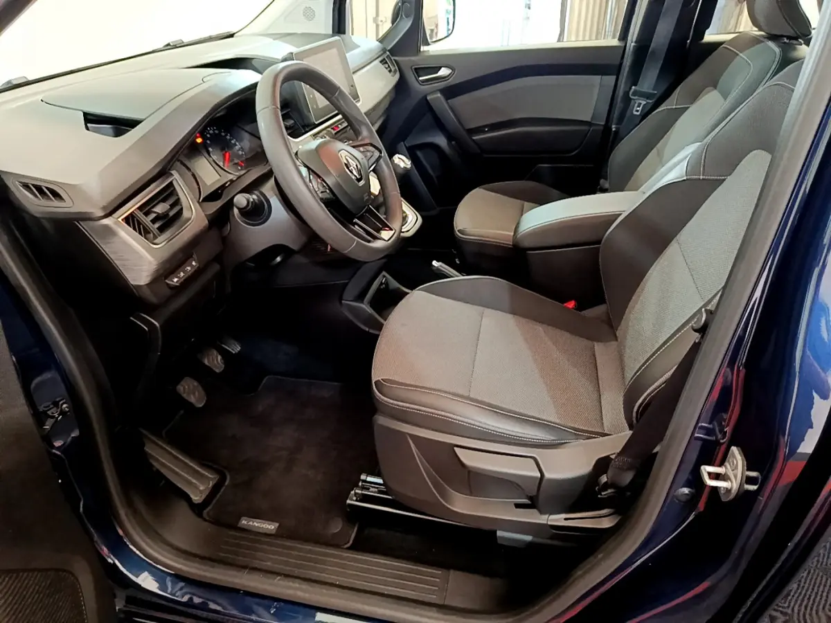 Intérieur avant droit du Renault Kangoo bleu 2023, sièges gris, volant multifonctions et tableau de bord moderne.