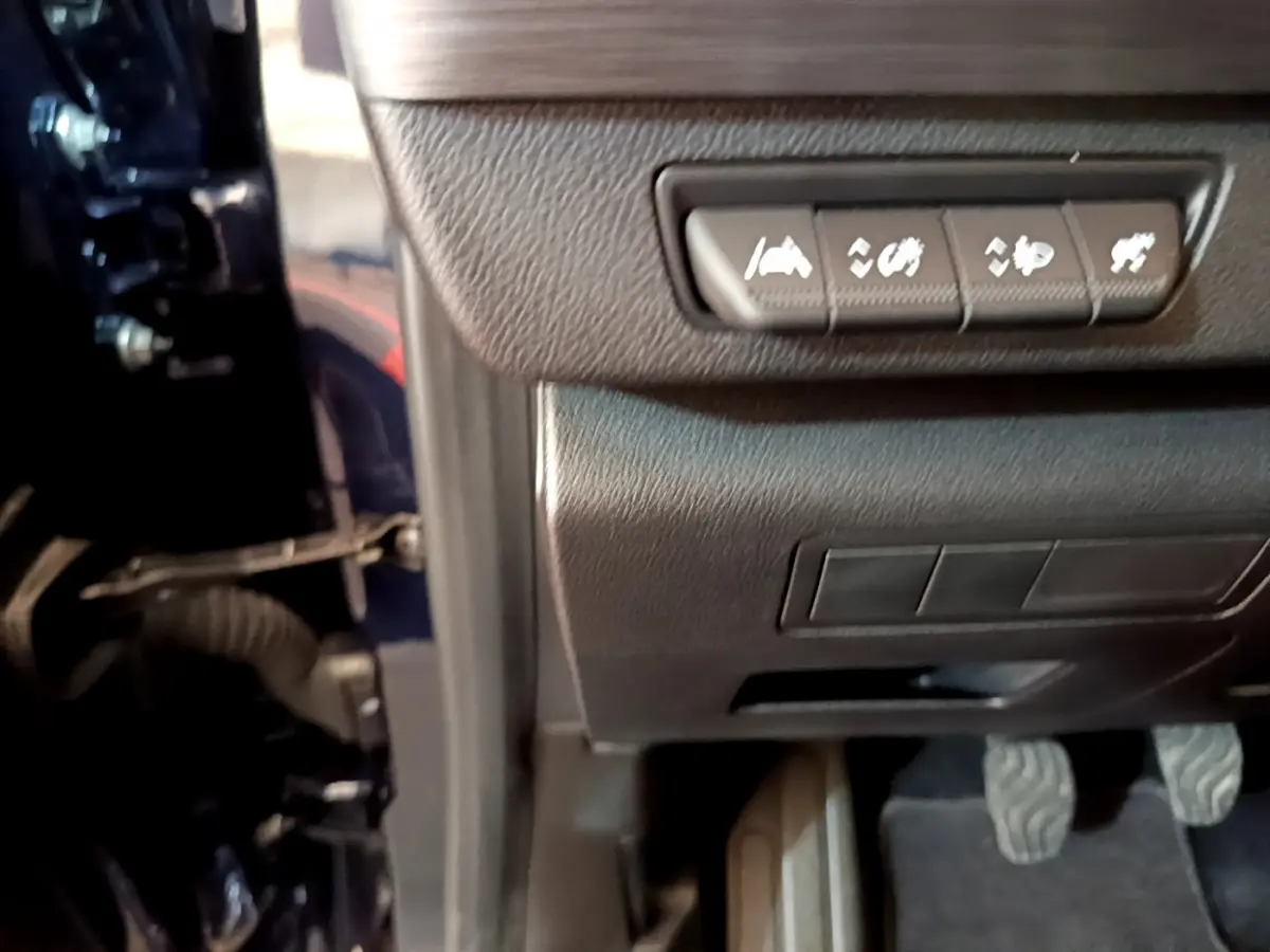 Vue intérieure côté conducteur du Renault Kangoo bleu 2023, montrant les commandes d'assistance et les pédales.