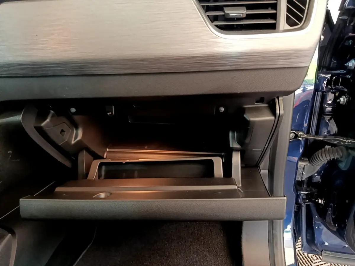 Intérieur du Renault Kangoo Equilibre 2023 bleu, vue sur la boîte à gants ouverte côté passager.