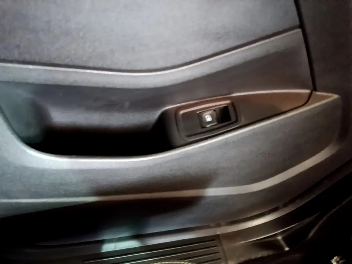 Gros plan sur la poignée intérieure de porte noire du Renault Kangoo Equilibre TCe 100 2023, finition sobre.