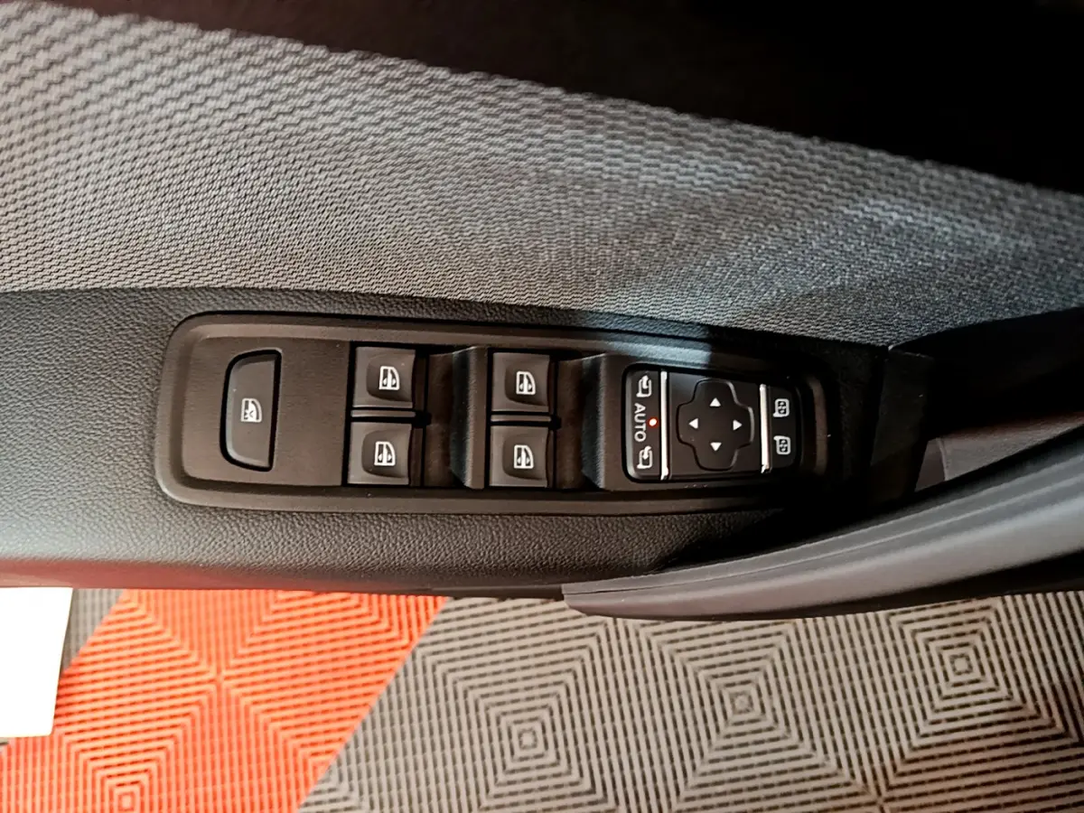 Panneau de commandes des vitres et rétroviseurs sur la portière côté conducteur du Renault Kangoo bleu 2023.