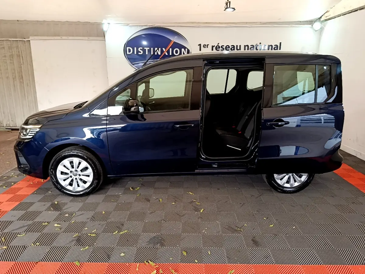 Profil gauche d'un Renault Kangoo bleu 2023 avec porte coulissante ouverte dévoilant l'intérieur noir.