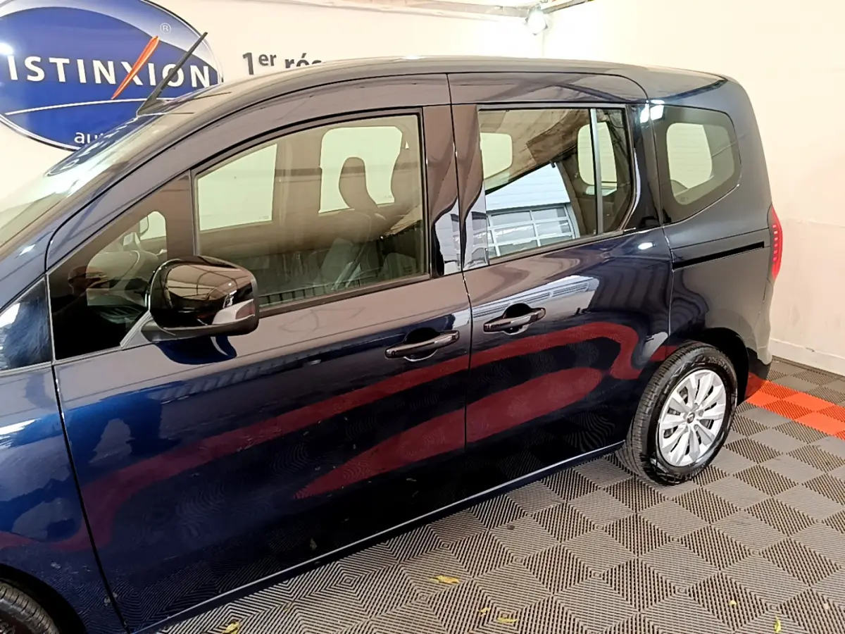 Profil côté droit du Renault Kangoo bleu 2023, mettant en valeur ses portes coulissantes et ses jantes alliage.