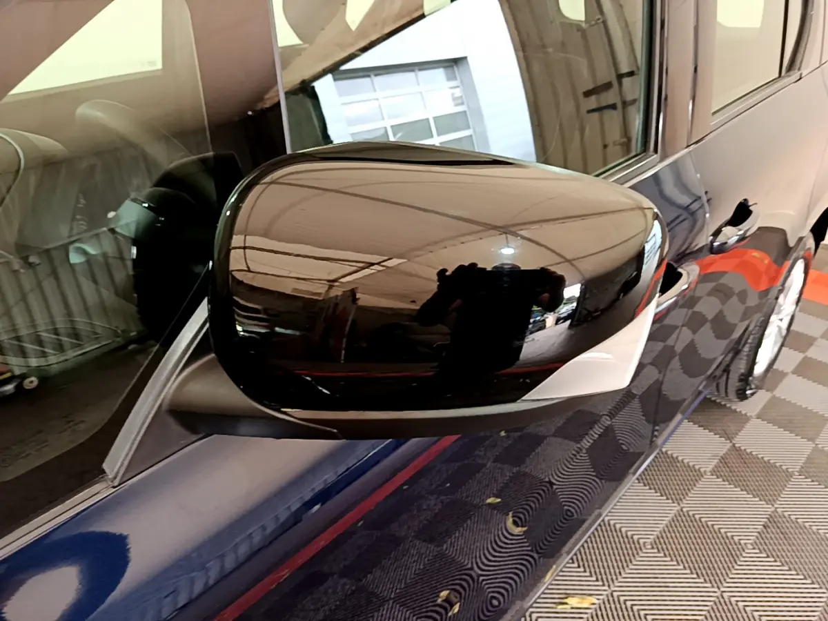 Rétroviseur droit noir brillant du Renault Kangoo bleu 2023, vue rapprochée côté passager avec reflet intérieur visible