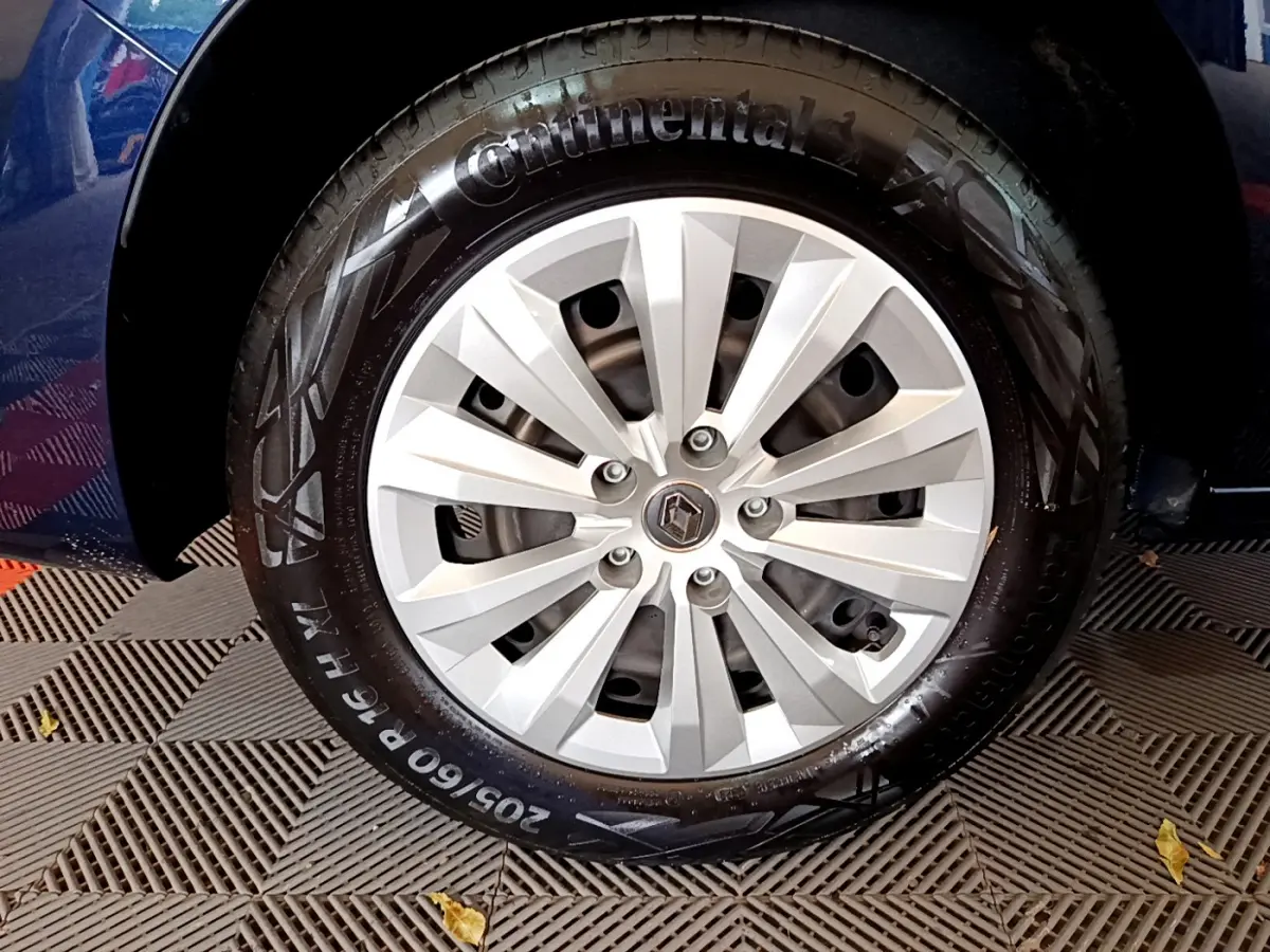 Gros plan sur la roue avant droite du Renault Kangoo bleu 2023 avec jante alliage et pneu Continental.