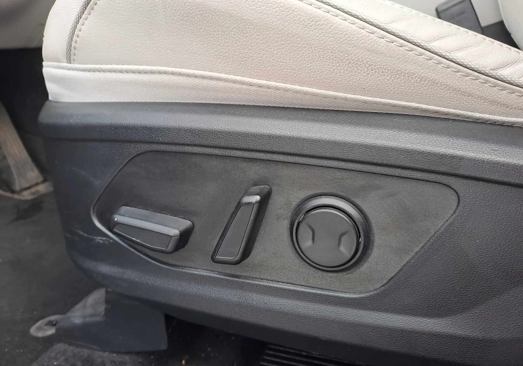 Détail des commandes électriques du siège beige côté conducteur dans un Hyundai Tucson 2023 hybride.