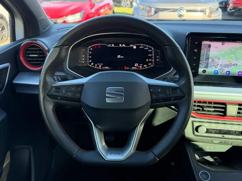 Vue intérieure centrée sur le volant multifonction d'une SEAT Ibiza 1.0 TSI 115cv FR avec tableau de bord numérique et écran tactile.