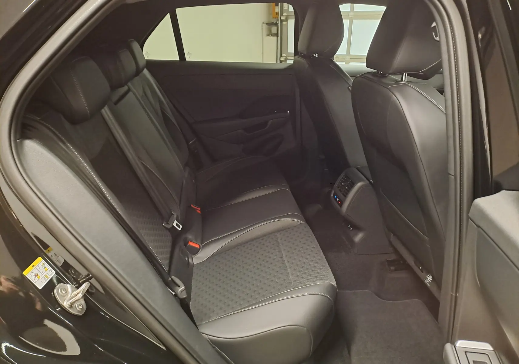 Vue intérieure côté gauche des sièges arrière noirs en cuir et tissu du Volkswagen T-Roc 2026 finition R-Line.