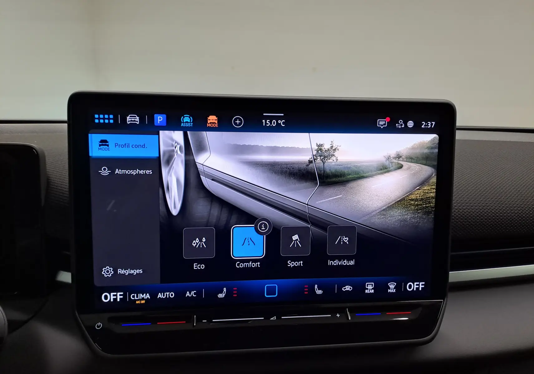 Écran tactile intérieur du Volkswagen T-Roc 2026 affichant les modes de conduite avec une roue et une route en arrière-plan.