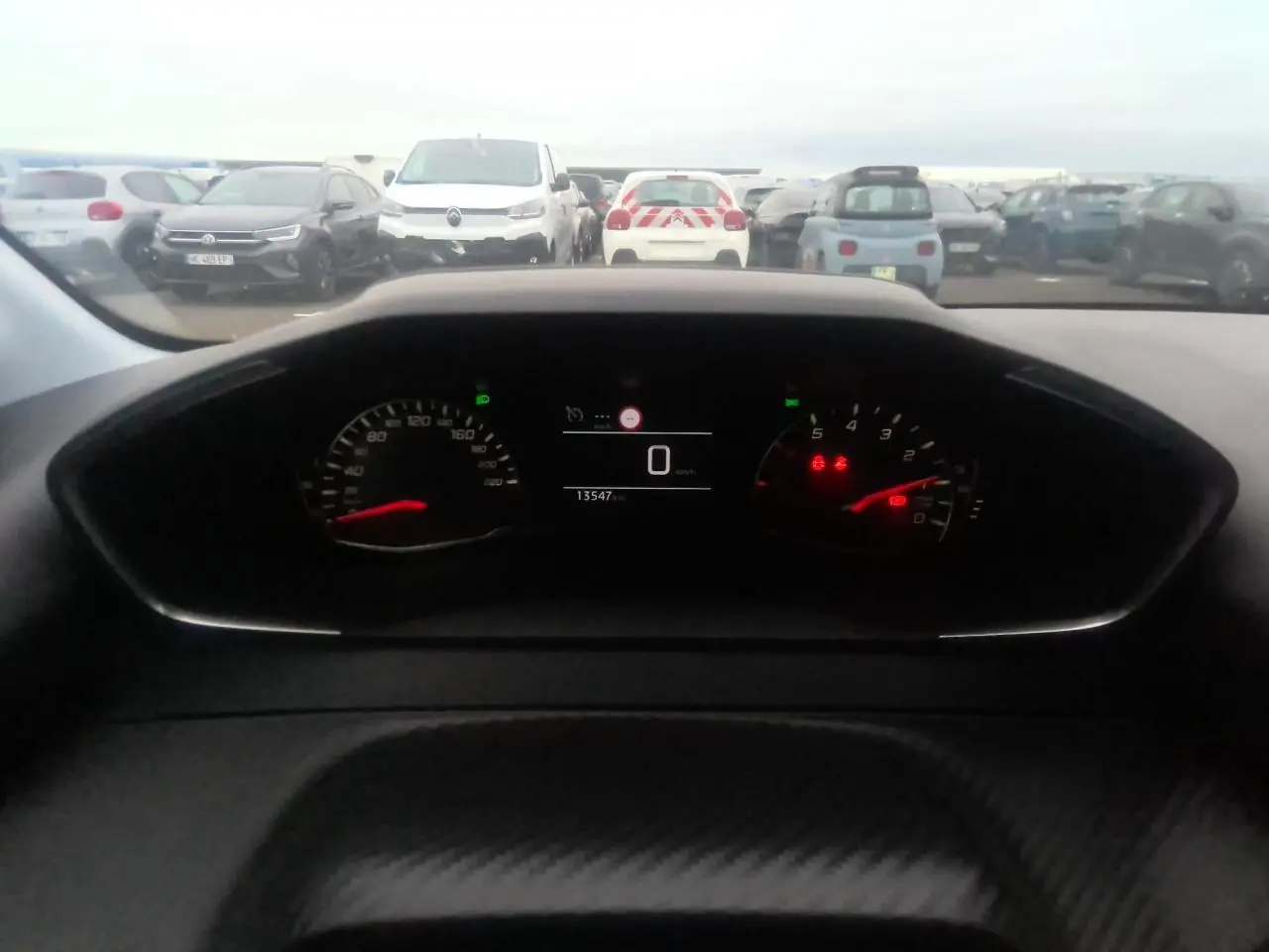 Vue du combiné d'instruments numérique et analogique de la Peugeot 208 2024, affichage au repos, tableau de bord noir.