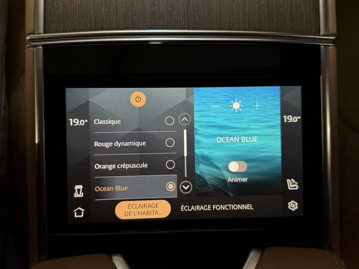 Écran tactile central du Range Rover PHEV 2024 affichant les réglages d’éclairage intérieur en mode Ocean Blue.