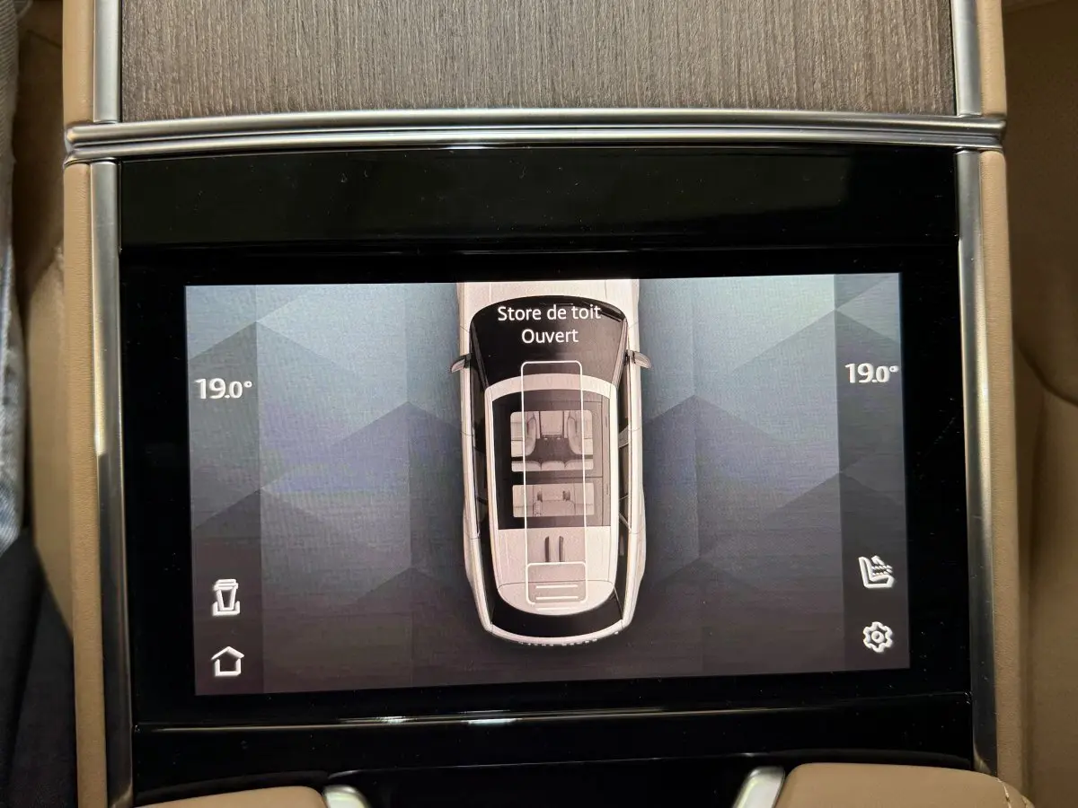 Écran tactile central montrant vue aérienne du Range Rover noir avec toit ouvrant ouvert, température 19°C.