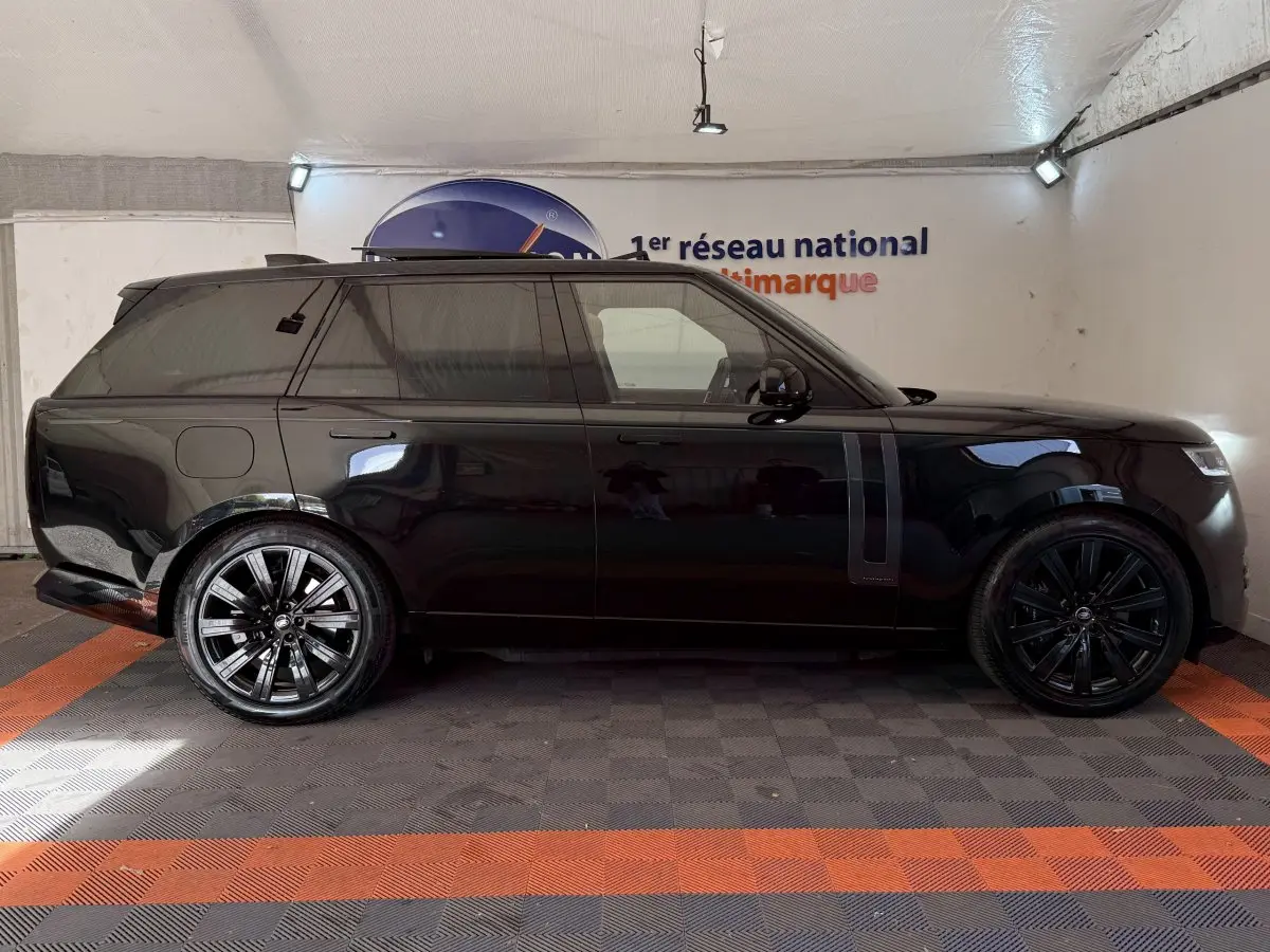 Vue de profil côté gauche d'un Range Rover PHEV P550e Autobiography noir brillant avec jantes noires en intérieur.