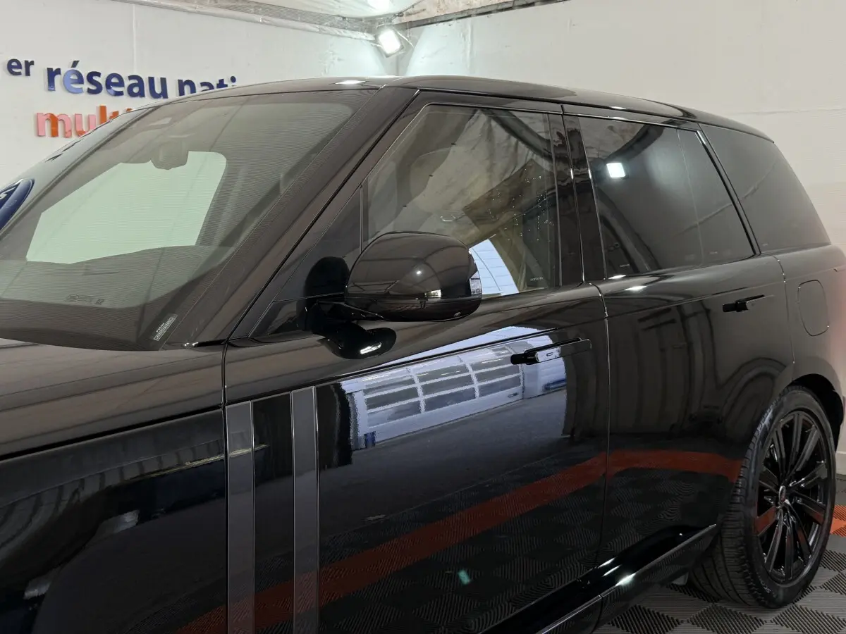 Vue latérale droite d’un Range Rover PHEV P550e Autobiography noir brillant avec rétroviseurs rabattables électriquement.