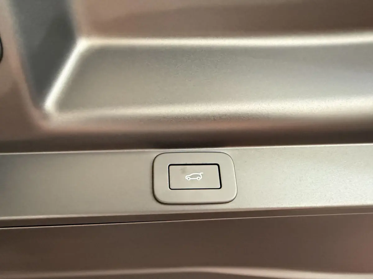 Bouton de fermeture électrique du coffre sur le panneau intérieur d’un Range Rover PHEV noir, vue rapprochée.