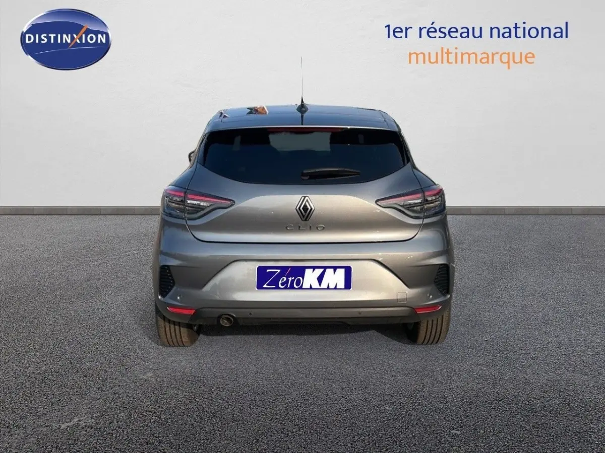 Vue arrière d'une Renault Clio gris métallisé 2025 garée devant un mur blanc avec logo Distinxion.