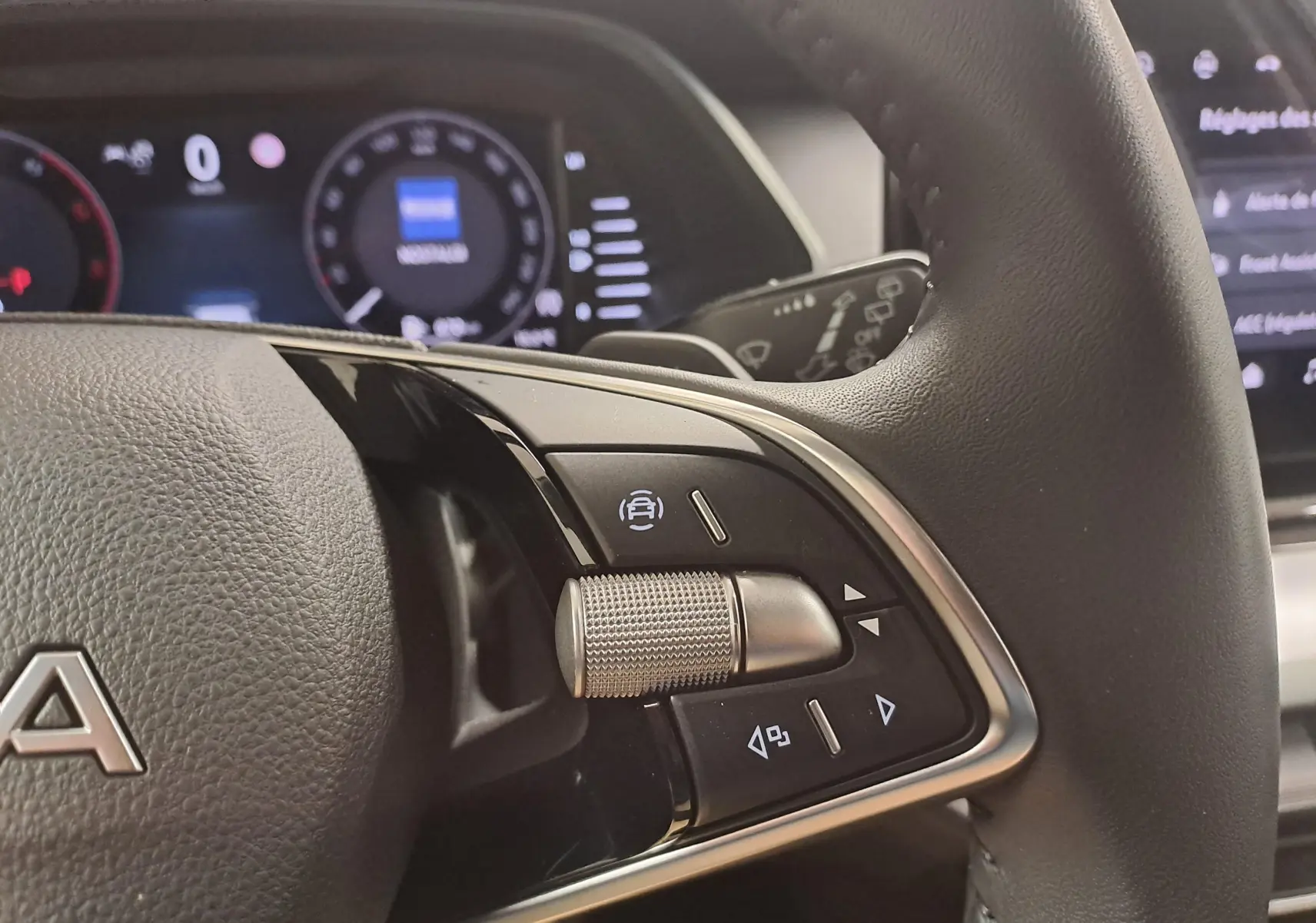 Gros plan sur le volant noir de la Skoda Octavia Combi 2025, montrant les commandes multifonctions avec molette métallique.