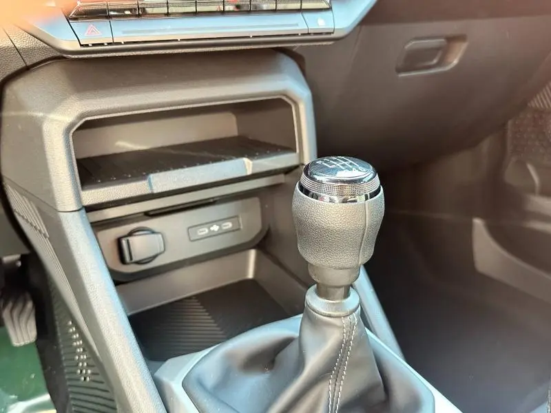 Gros plan sur le levier de vitesse manuel noir et gris du Dacia Bigster 2025, avec console centrale et ports USB visibles.