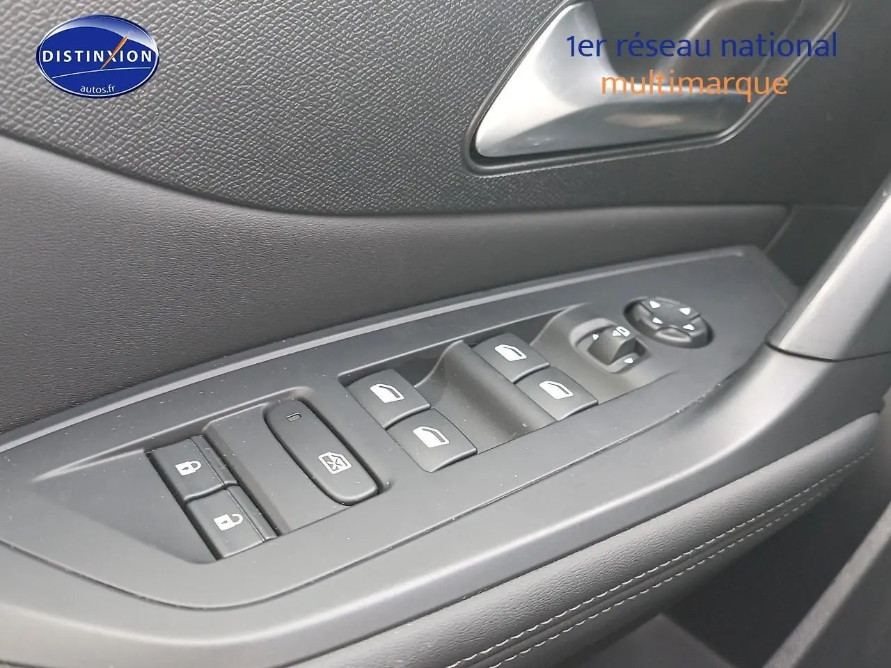 Gros plan sur les commandes des vitres et rétroviseurs côté conducteur d’une Peugeot 308 SW gris sélénite.