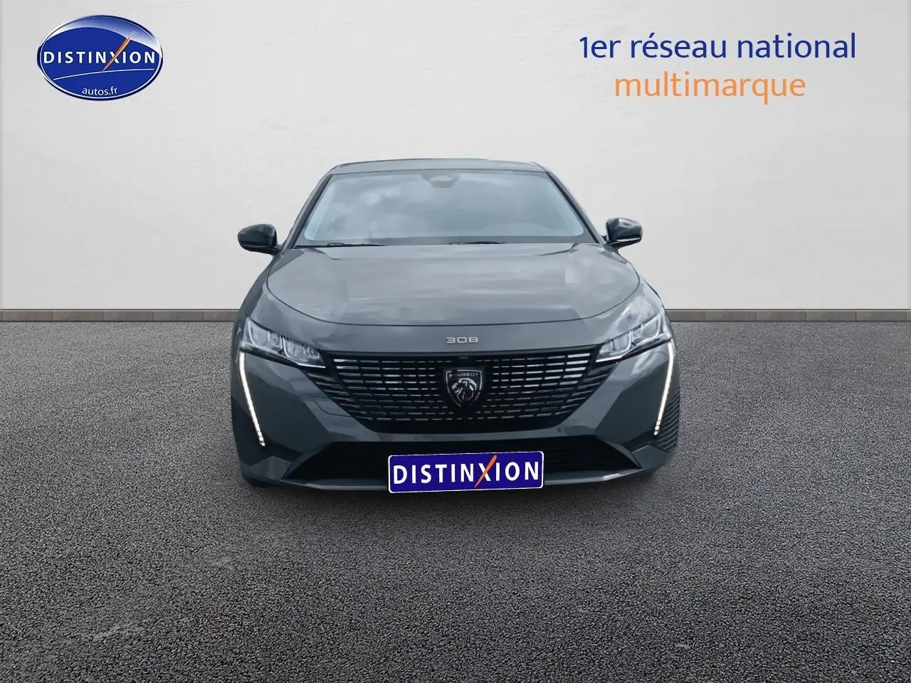 Vue frontale d'une Peugeot 308 SW gris sélénite avec calandre noire et feux LED verticaux allumés.
