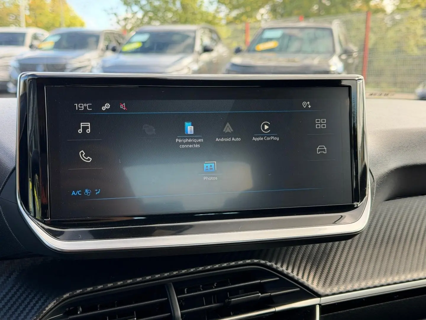 Écran tactile central du tableau de bord de la Peugeot 208 gris Artense, avec interface Android Auto et Apple CarPlay visible.