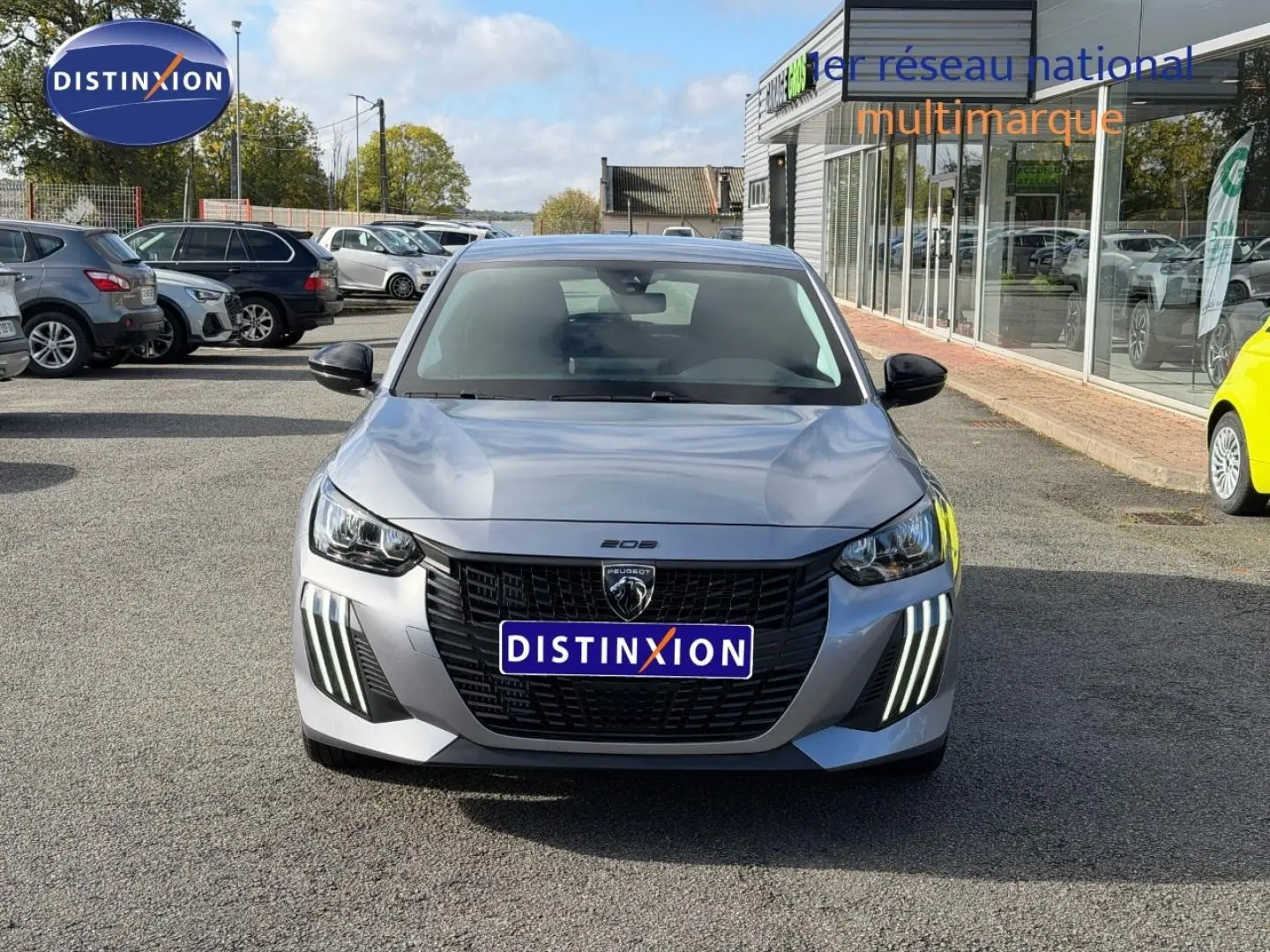 Peugeot 208 gris Artense vue de face, mettant en valeur la calandre noire et les feux LED verticaux distinctifs.