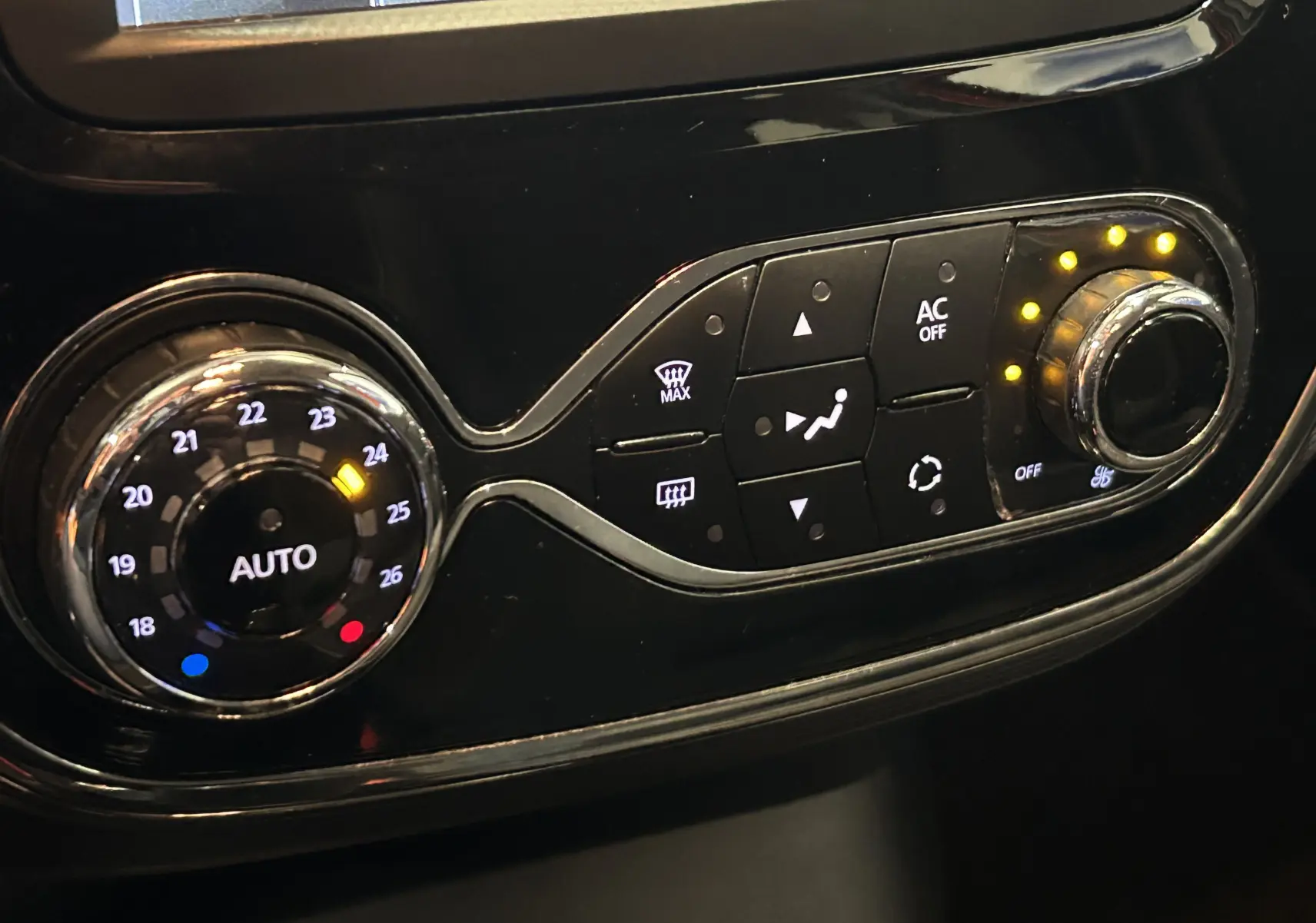 Panneau de commande de climatisation automatique du Renault Captur orange 2014, avec réglages lumineux et boutons fonctionnels.