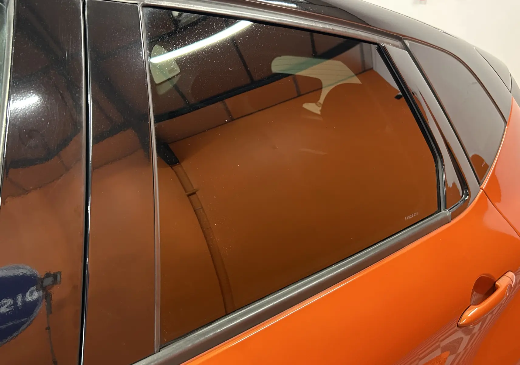 Vue latérale droite sur la porte arrière orange d'un Renault Captur dCi 90ch energy Intens 2014 avec vitres teintées.