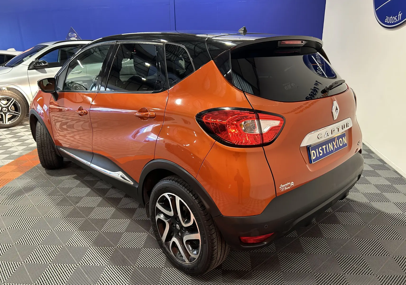 Renault Captur dCi 90ch Intens orange vu en 3/4 arrière droit, toit noir et jantes alliage distinctives.