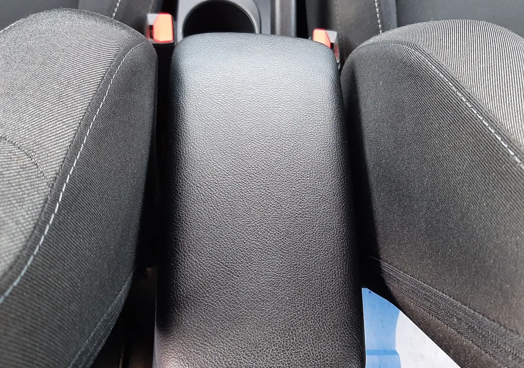 Gros plan sur l'accoudoir central noir en cuir entre les sièges avant en tissu gris du Renault Captur 2020.