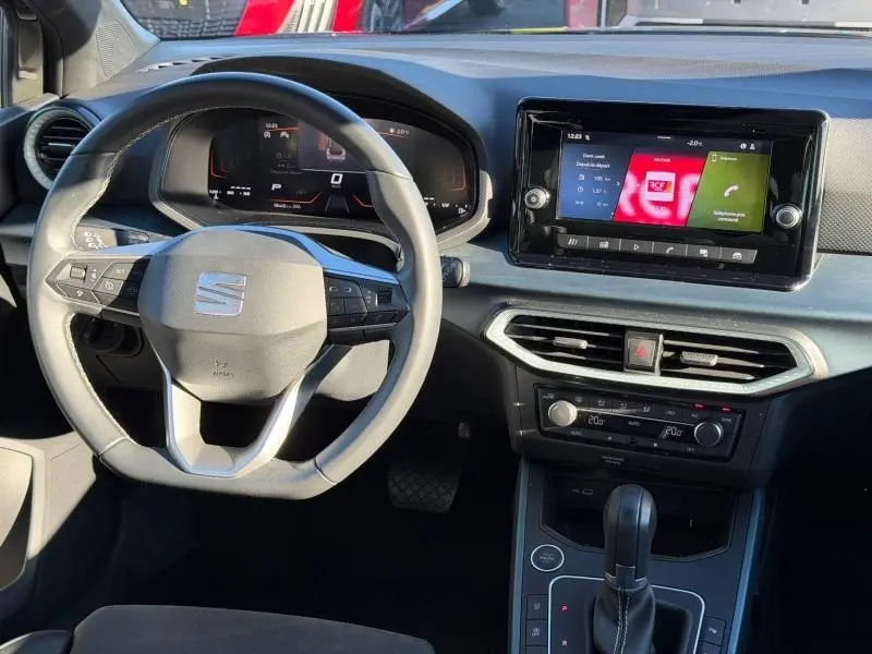 Vue intérieure du tableau de bord et volant du SEAT Arona 2025, avec écran tactile et commandes au volant visibles.