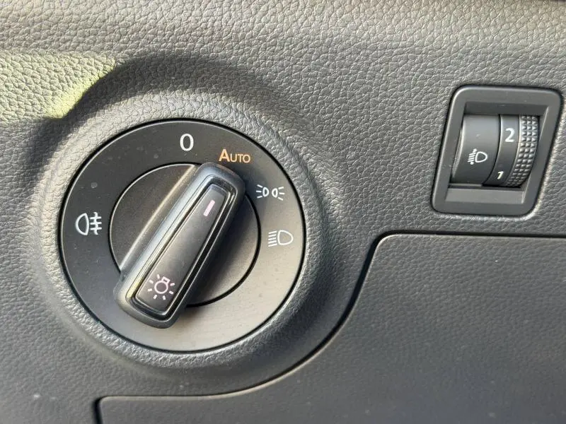 Détail du tableau de bord du SEAT Arona 2025 montrant la molette de réglage des phares sur fond noir texturé.