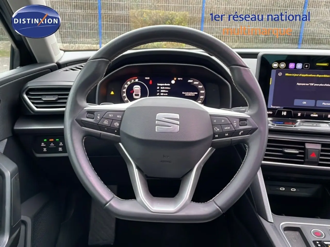 Vue intérieure centrée sur le volant de la SEAT LEON 2025 avec tableau de bord numérique et écran tactile.