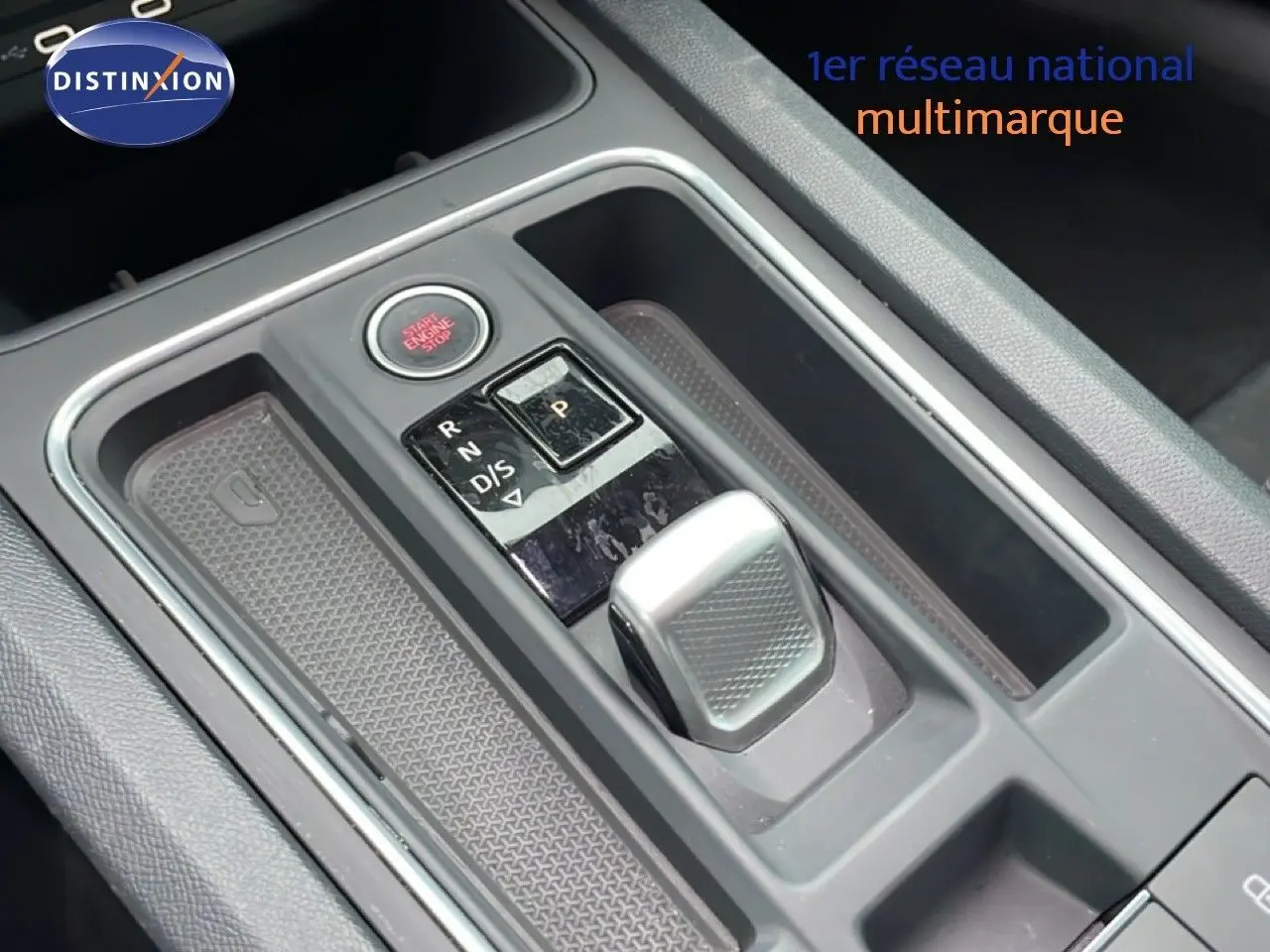 Gros plan sur la console centrale de la SEAT LEON IV gris Fiord, montrant le levier de vitesses automatique et bouton start/stop.