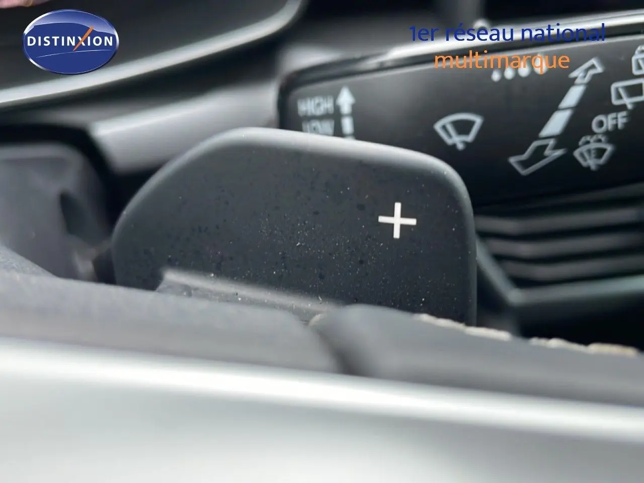 Gros plan sur la palette de changement de vitesse "+" du volant d'une SEAT LEON IV gris Fiord, version 2025.