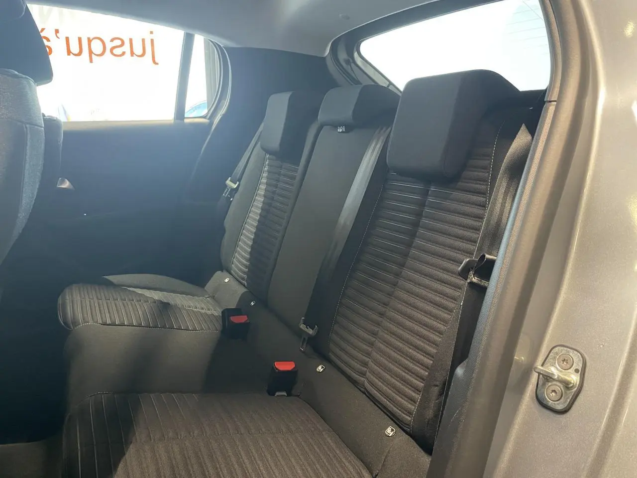 Vue intérieure côté droit sur la banquette arrière tissu noir de la Peugeot 208 gris clair 2024.