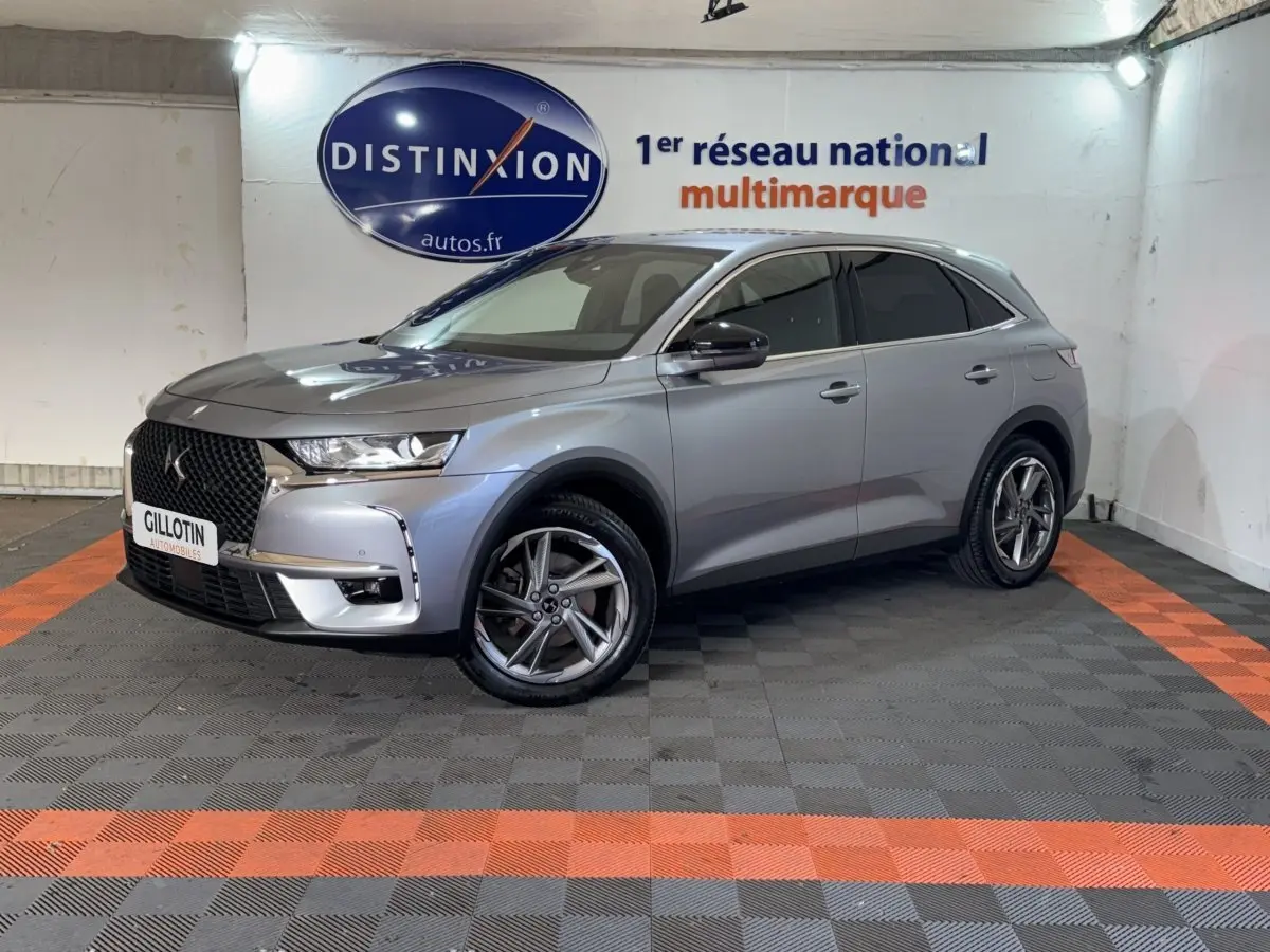 DS7 Crossback E-TENSE gris foncé en 3/4 avant droit, avec calandre distinctive et jantes alliage visibles.