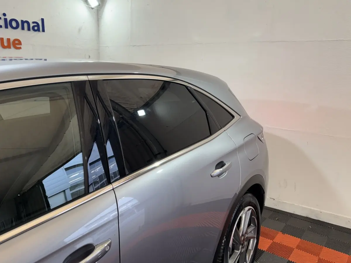 Vue côté droit arrière du DS7 Crossback E-TENSE gris foncé, mettant en valeur la porte, la vitre teintée et la jante alliage.