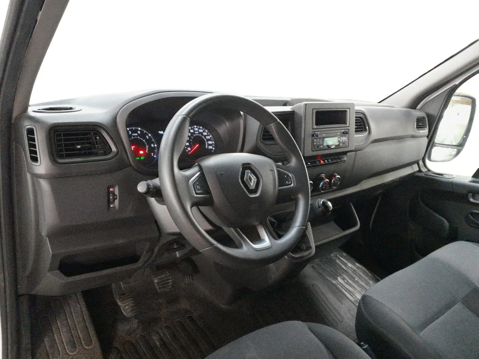 Vue intérieure côté conducteur du Renault Master 2023, tableau de bord noir avec volant multifonction et console centrale intégrée.