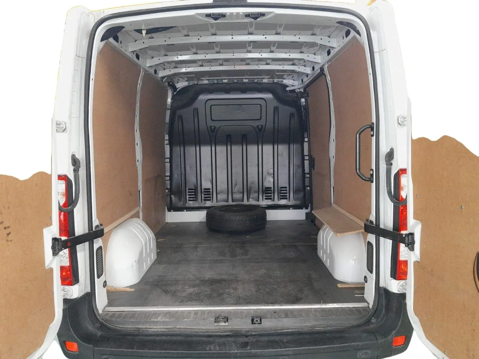 Vue arrière ouverte du Renault Master blanc 2023, montrant l'espace de chargement vide avec un pneu de secours au sol.
