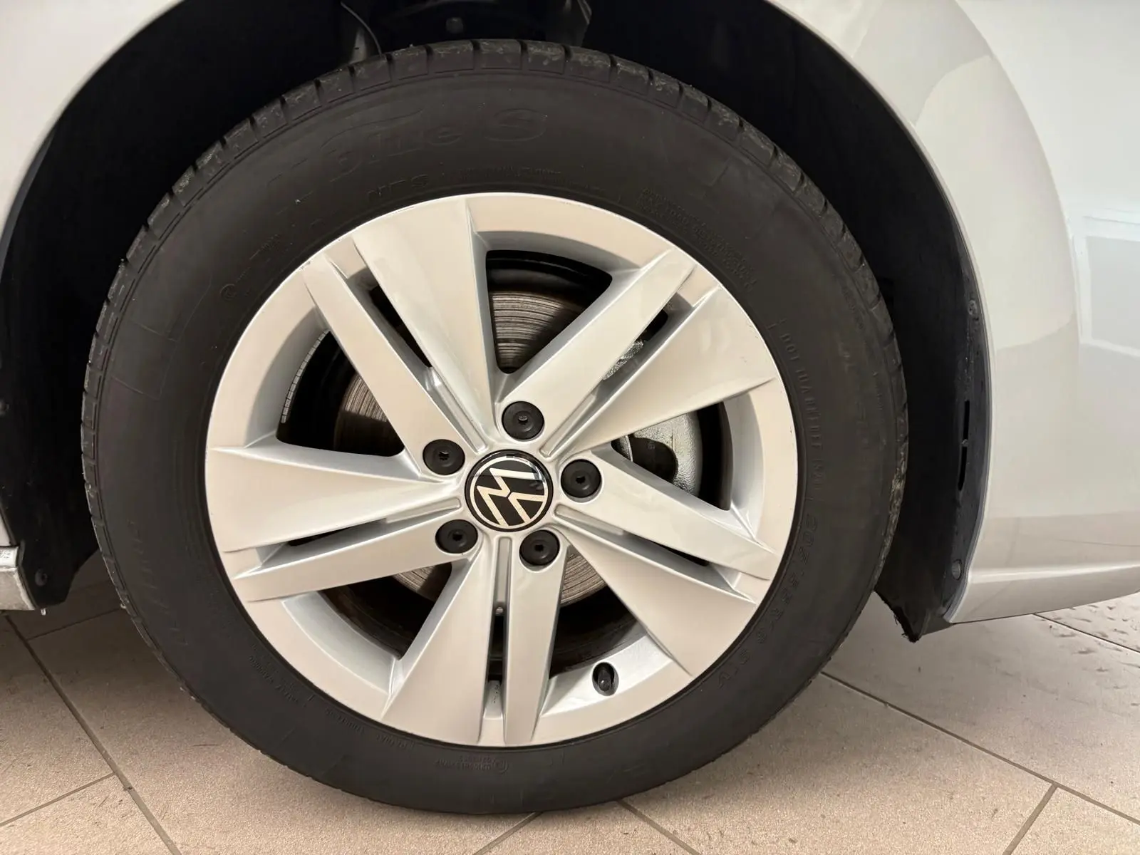 Gros plan sur la roue avant droite argentée d'une Volkswagen Golf 2.0 TDI 2025 avec jante en alliage distincte.