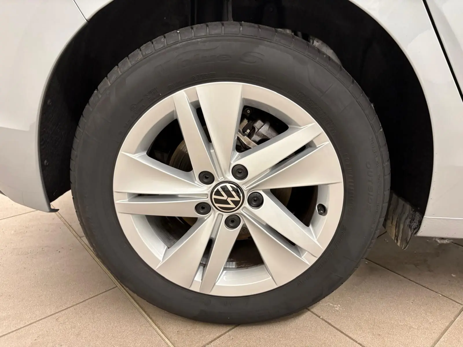 Gros plan sur la roue avant droite de la Volkswagen Golf 2.0 TDI 2025 en reflet d'argent avec jante alliage à cinq doubles branches.