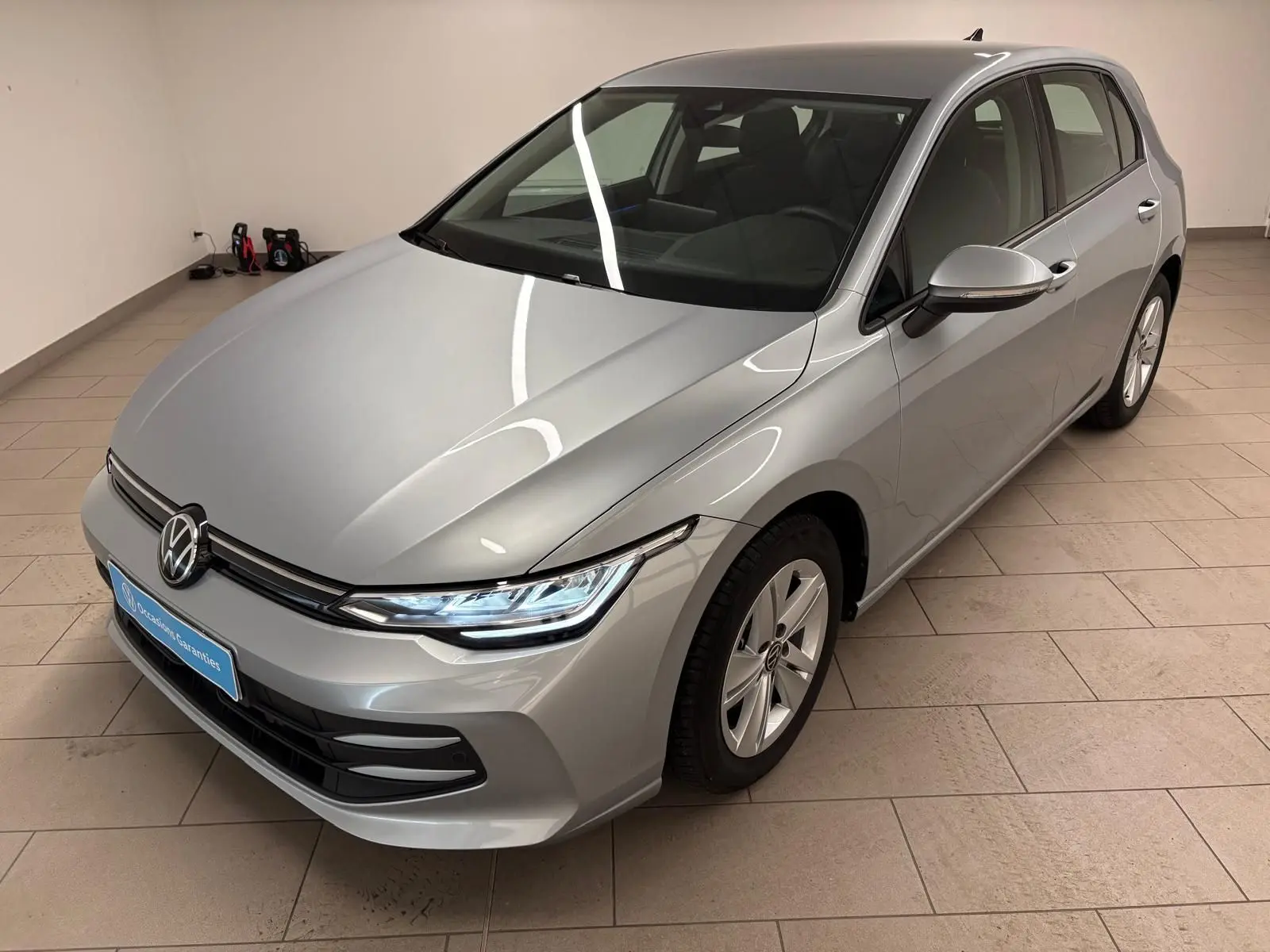 Volkswagen Golf 2.0 TDI 116 BVM6 Life Plus 2025 en reflet d'argent vue 3/4 avant droit dans un intérieur.