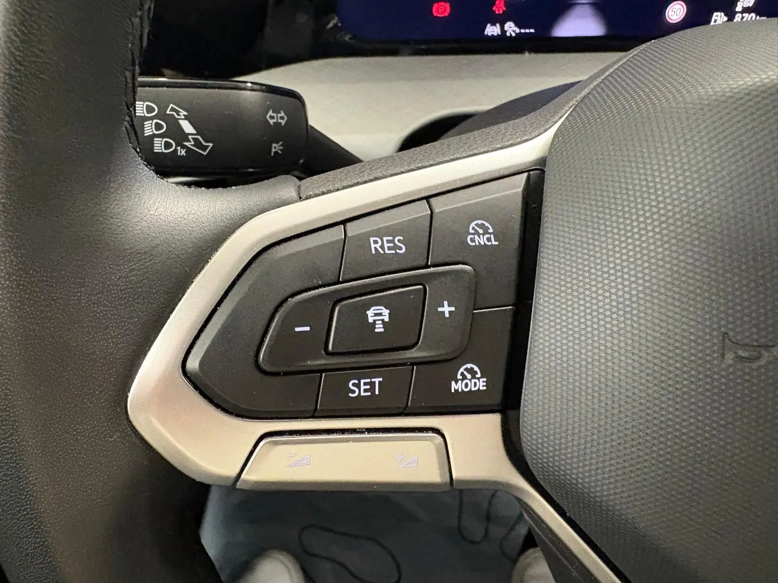 Gros plan sur les commandes au volant côté gauche de la Volkswagen Golf 2.0 TDI 2025 couleur reflet d'argent.